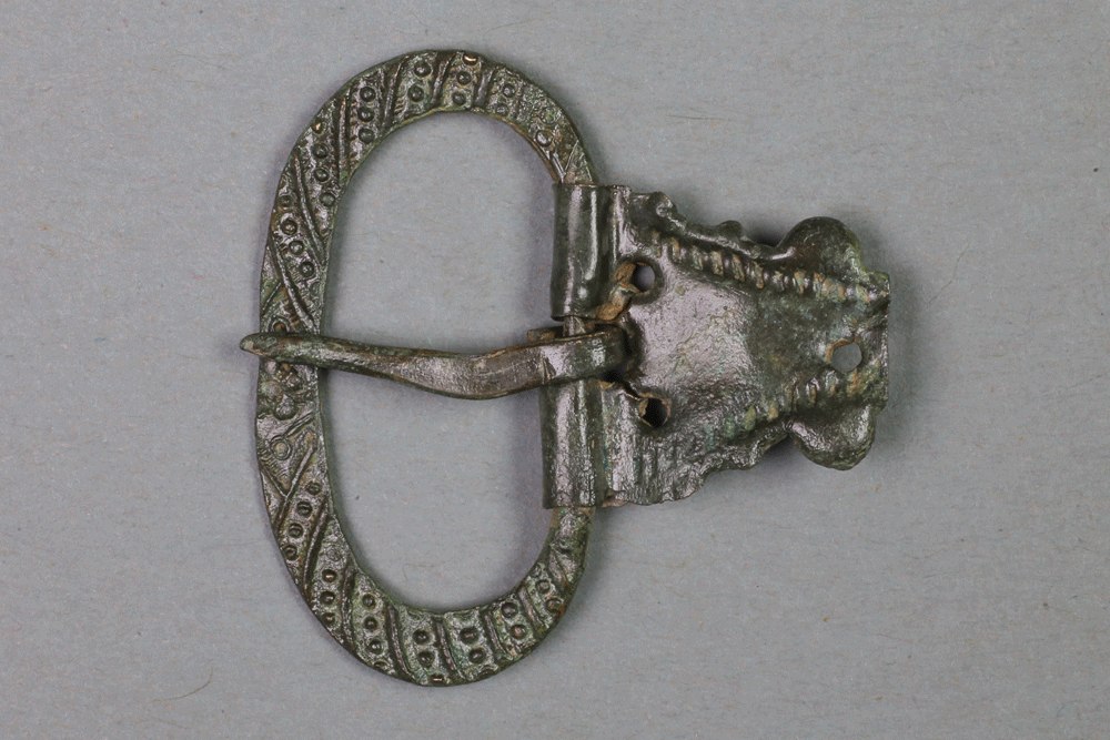 Schnalle aus Messing von der Burg Bartenstein, 15. Jh., Partenstein, Museum Ahler Kram, Fd. Nr. 2046, H. 3,3 cm, Br. 3,3 cm