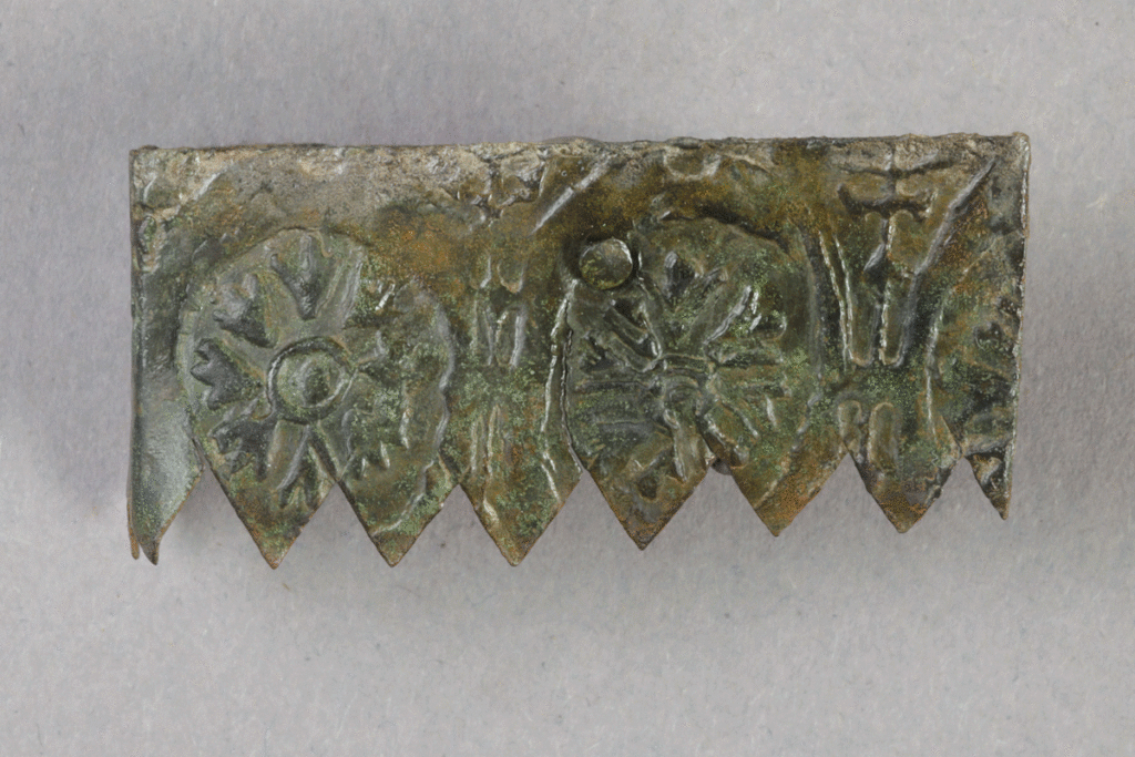 Fragment eines Beschlags aus Buntmetall von der Burg Bartenstein, Partenstein,14. Jh., Museum Ahler Kram, Fd. Nr. 3104a, H. 2,0 cm, Br. 4,2 cm