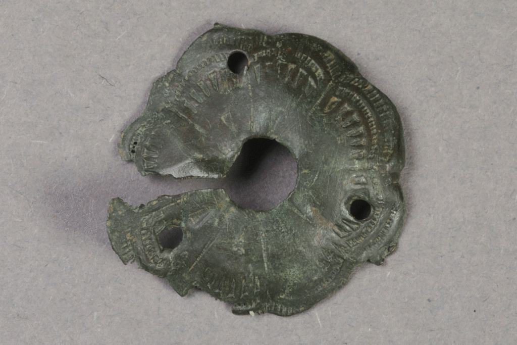 Fragment eines Beschlags aus Messing von der Burg Bartenstein, Partenstein, 15. Jh., Museum Ahler Kram, Fd. Nr. 1438, H. 1,0 cm, Br. 1,1 cm