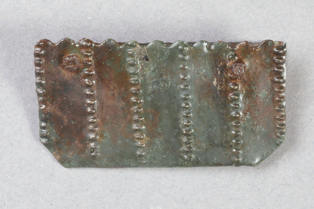 Fragment eines Beschlags aus Buntmetall von der Burg Bartenstein, Partenstein, 15. Jh., Museum Ahler Kram, Fd. Nr. 1229, H. 1,7 cm, Br. 3,3 cm