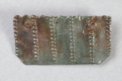 Fragment eines Beschlags aus Messing von der Burg Bartenstein, Partenstein, 15. Jh., Museum Ahler Kram, Fd. Nr. 1229, H. 1,7 cm, Br. 3,3 cm