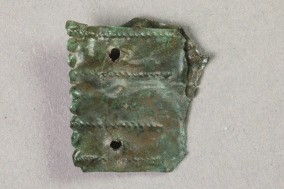 Fragment eines Beschlags aus Messing von der Burg Bartenstein, Partenstein, 16. Jh., Museum Ahler Kram, Fd. Nr. 1538, H. 2,6 cm, Br. 2,5 cm
