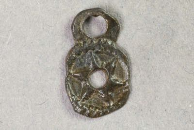 Fragment eines Beschlags aus Messing von der Burg Bartenstein, Partenstein, Datierung unklar, Museum Ahler Kram, Fd. Nr. 2525, H. 1,2 cm, Br. 0,7 cm