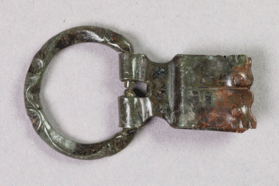 Schnalle aus Buntmetall von der Burg Bartenstein, Anfang 14. Jh., Partenstein, Museum Ahler Kram, Fd. Nr. 1215, H. 2,8 cm, Br. 4,8 cm