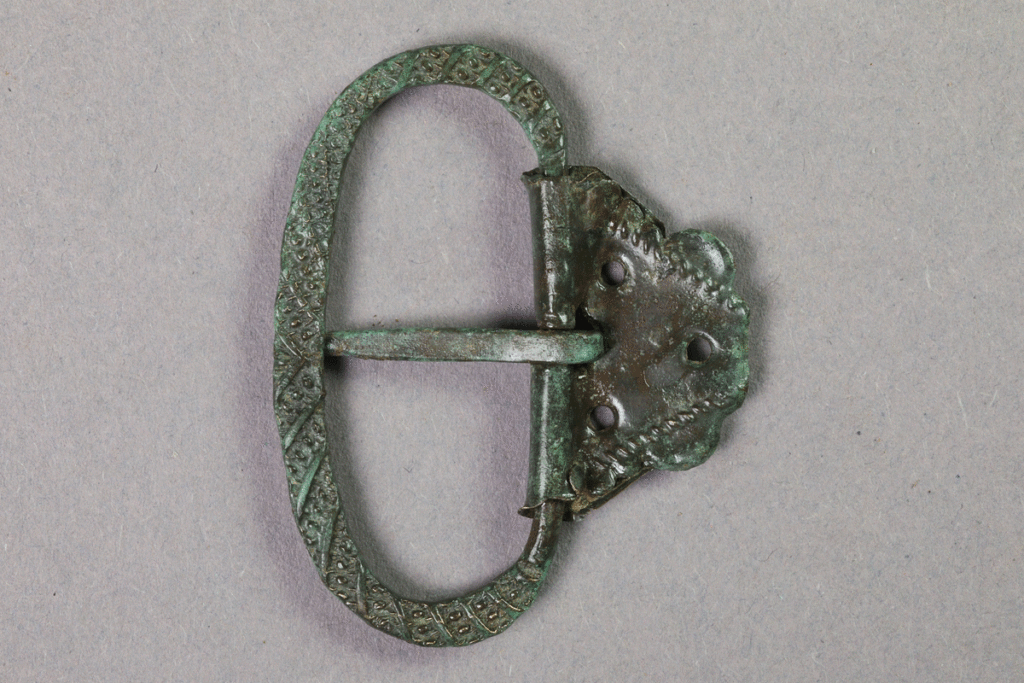 Schnalle aus Buntmetall von der Burg Bartenstein, 15. Jh., Partenstein, Museum Ahler Kram, Fd. Nr. 1960, H. 4,4 cm, Br. 3,5 cm