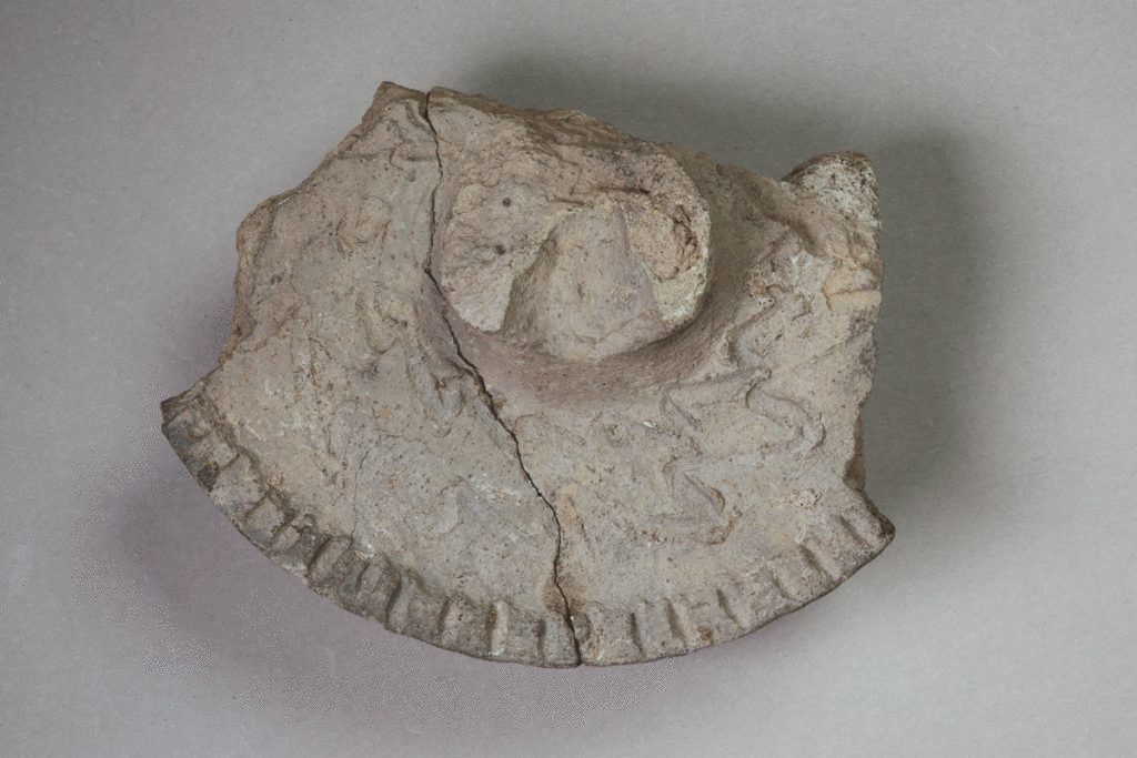 Fragment eines Deckels aus Ziegelton von der Burg Bartenstein, Keramik, 14. Jh.., Partenstein, Museum Ahler Kram, Fd. Nr. 3146a, H. 2,4 cm, Br. 10,0 cm